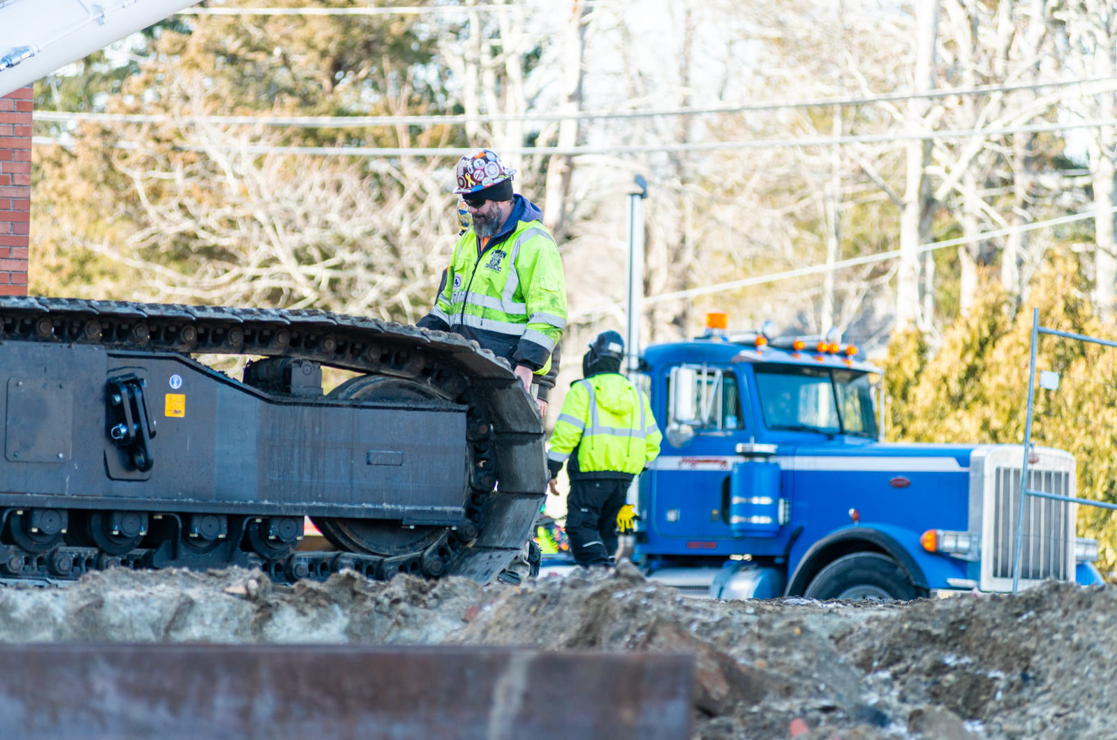 Workers reposition heavy machinery outside the school.