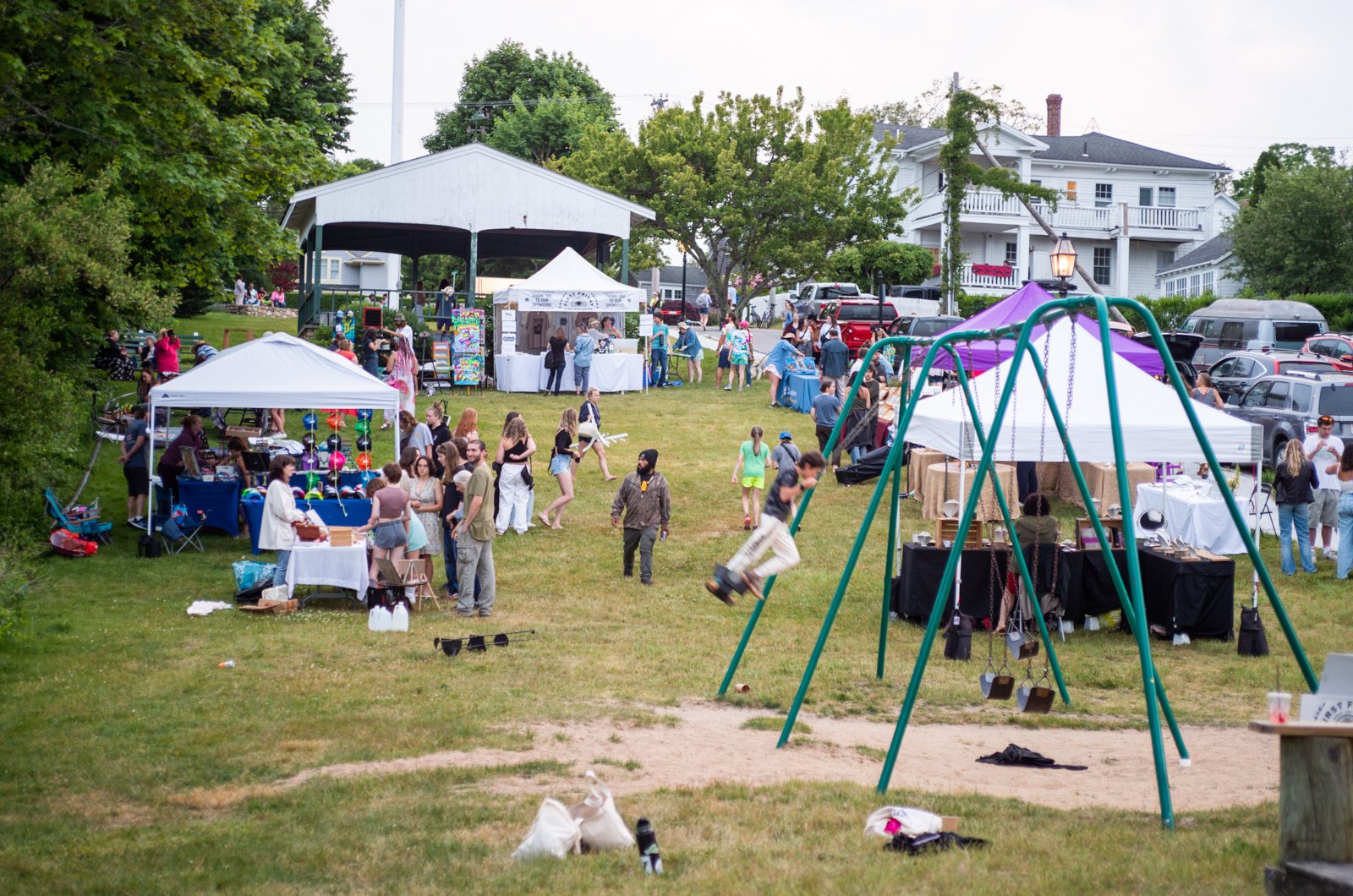 Vendors and artisans are concentrated on the grass around the bandstand.