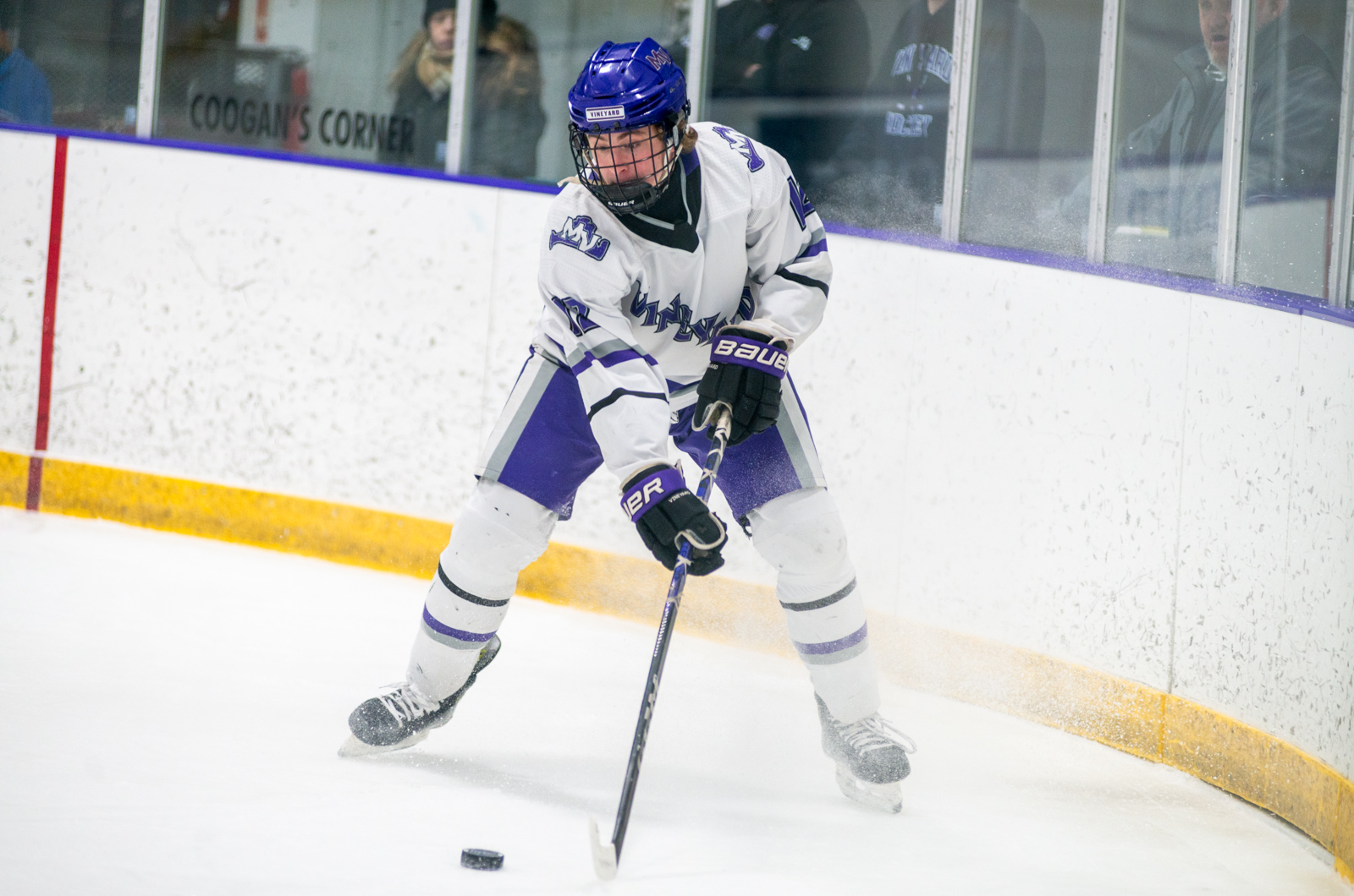 Liam Conley with the puck behind the net.