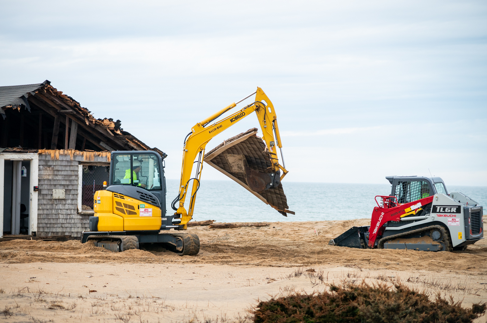 Excavator moves debris to the dumpster.