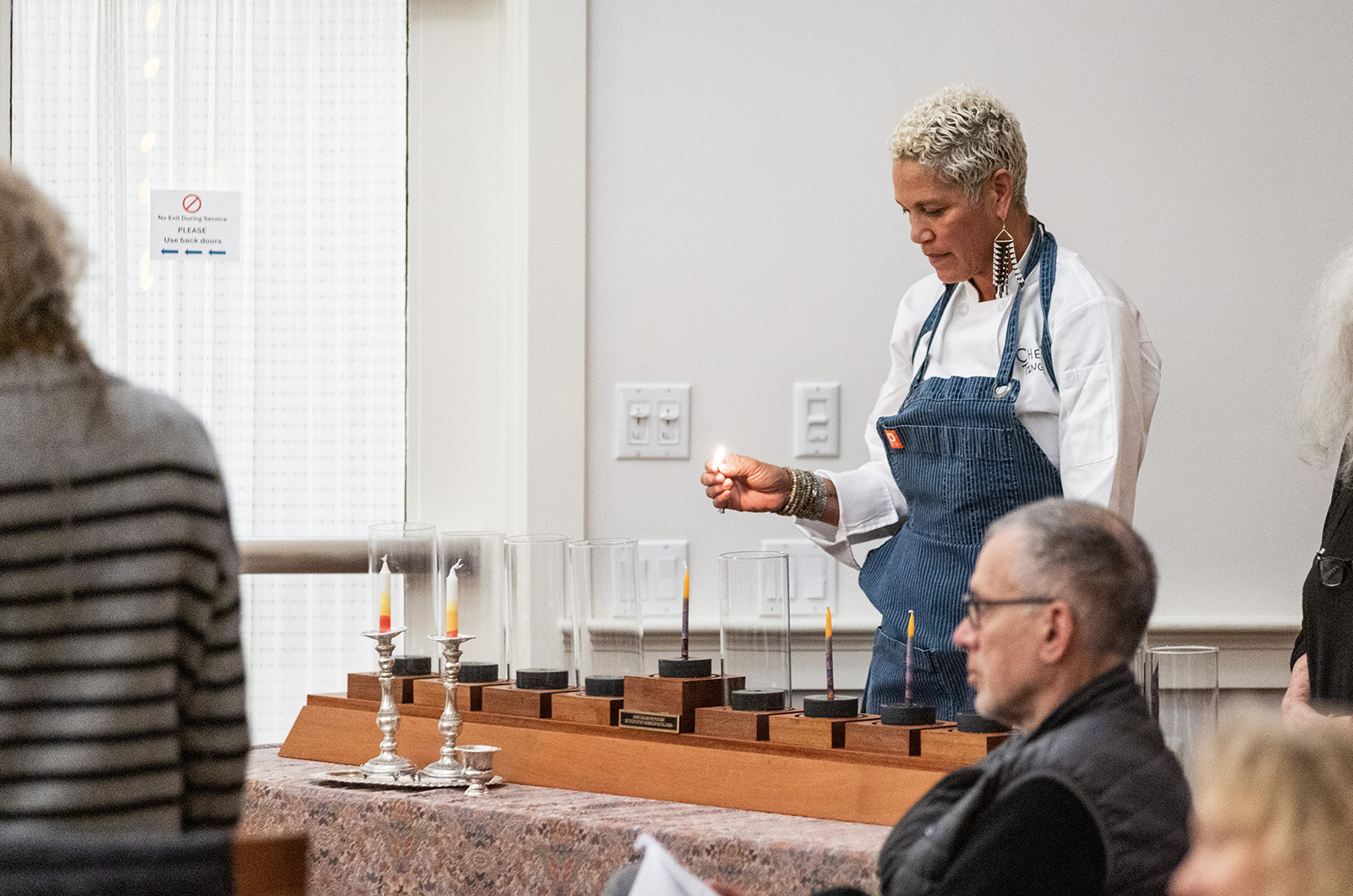 Chef Ting lights the first candle on the menorah.