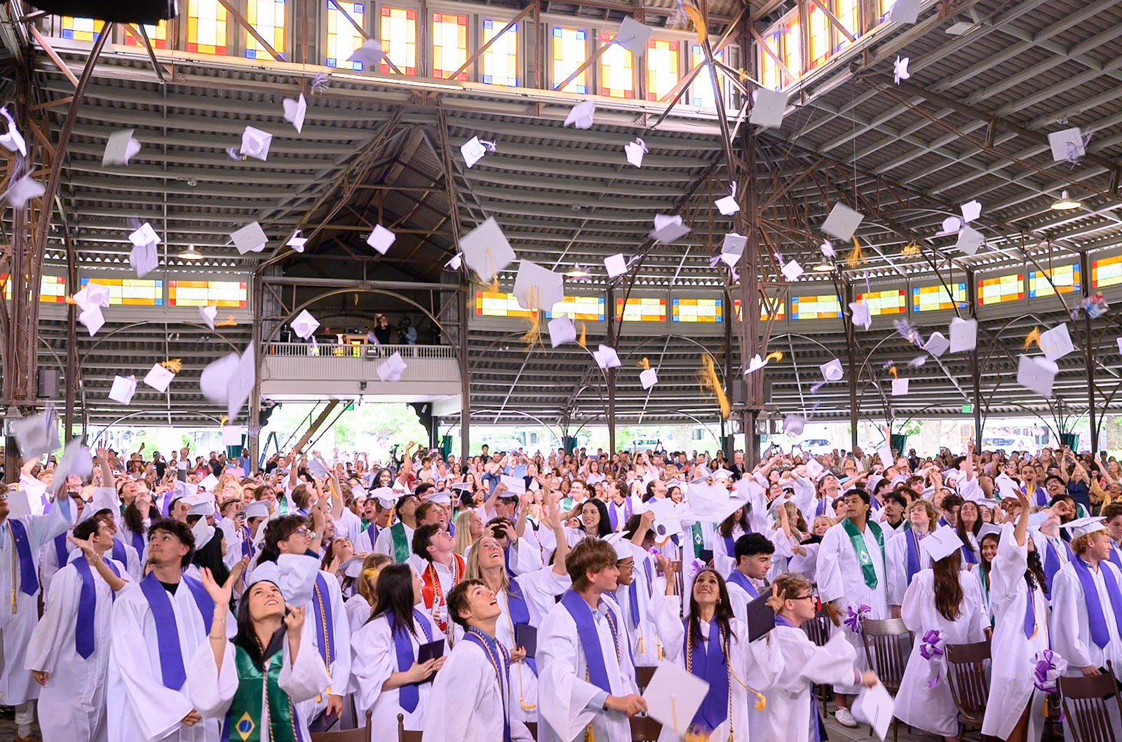 Graduates throw their caps in the air.