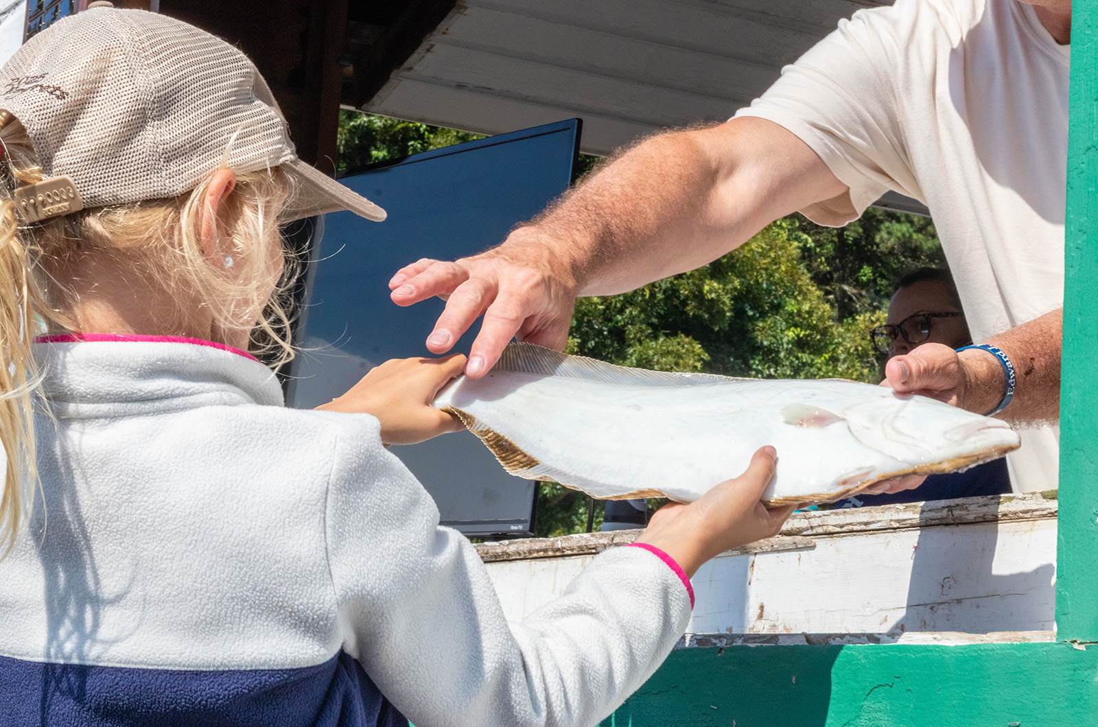 Julia Komalski weighs in a fish.
