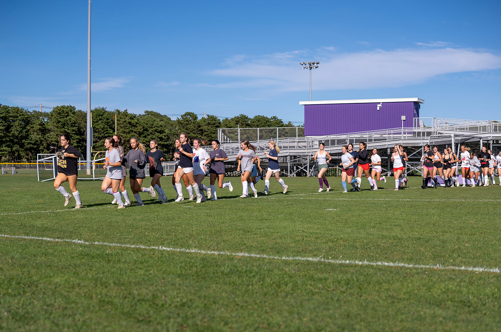 Girls lacrosse team running laps.