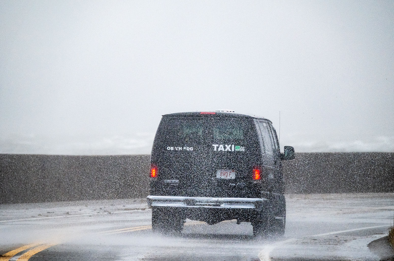 Taxi braves the weather at the sea wall.