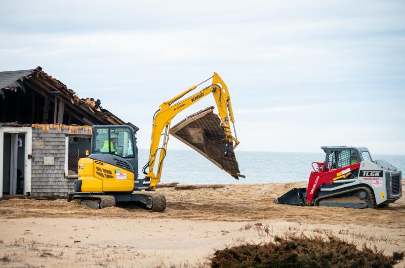 Excavator moves debris to the dumpster.