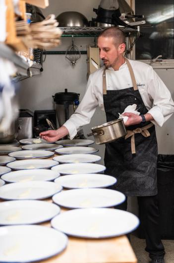 Cristopher Stam plating dishes in the kitchen.