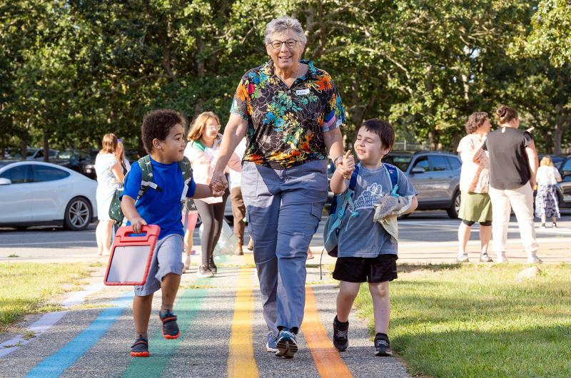 West Tisbury teacher Kate walking two youngsters to class.