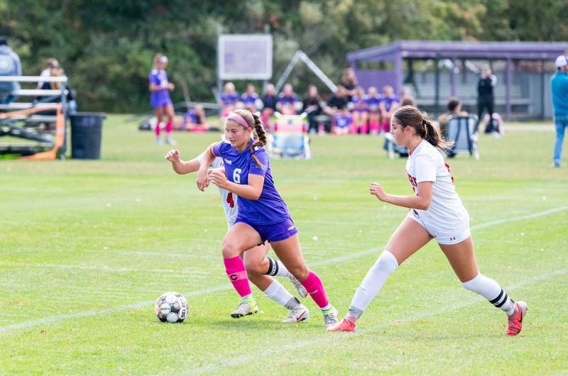 Reese Malowski pushing past defenders.
