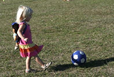 little girl kicks ball