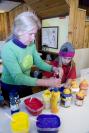 woman teaches young girl crafts