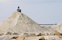 mountain of sand with man sitting on top