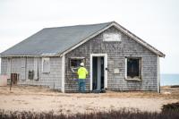 Removing windows before demolition begins.