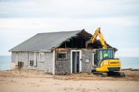 The street-facing wall begins to come down.