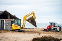 Excavator moves debris to the dumpster.