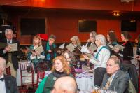 The Scottish Singers sing from their seats.