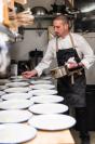 Cristopher Stam plating dishes in the kitchen.