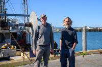 Todd and Matthew Mayhew next to the boat they co-own, the Lady M.