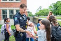 Resource Officer Cory Medeiros plays patty-cake with Scarlett Garcia.
