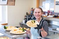 Marlucia Boulet plating food ahead of lunch time.